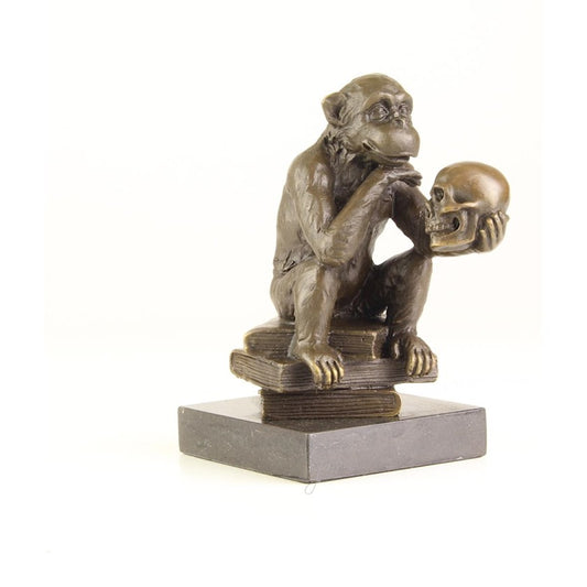 Bronzen beeld van een Darwin aap die op boeken zit te filosoferen met een schedel in zijn hand