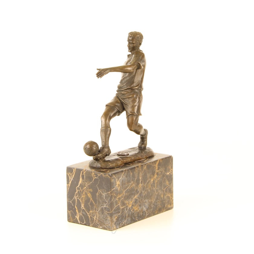Bronzen beeld van een voetballer met de bal aan zijn rechtervoet